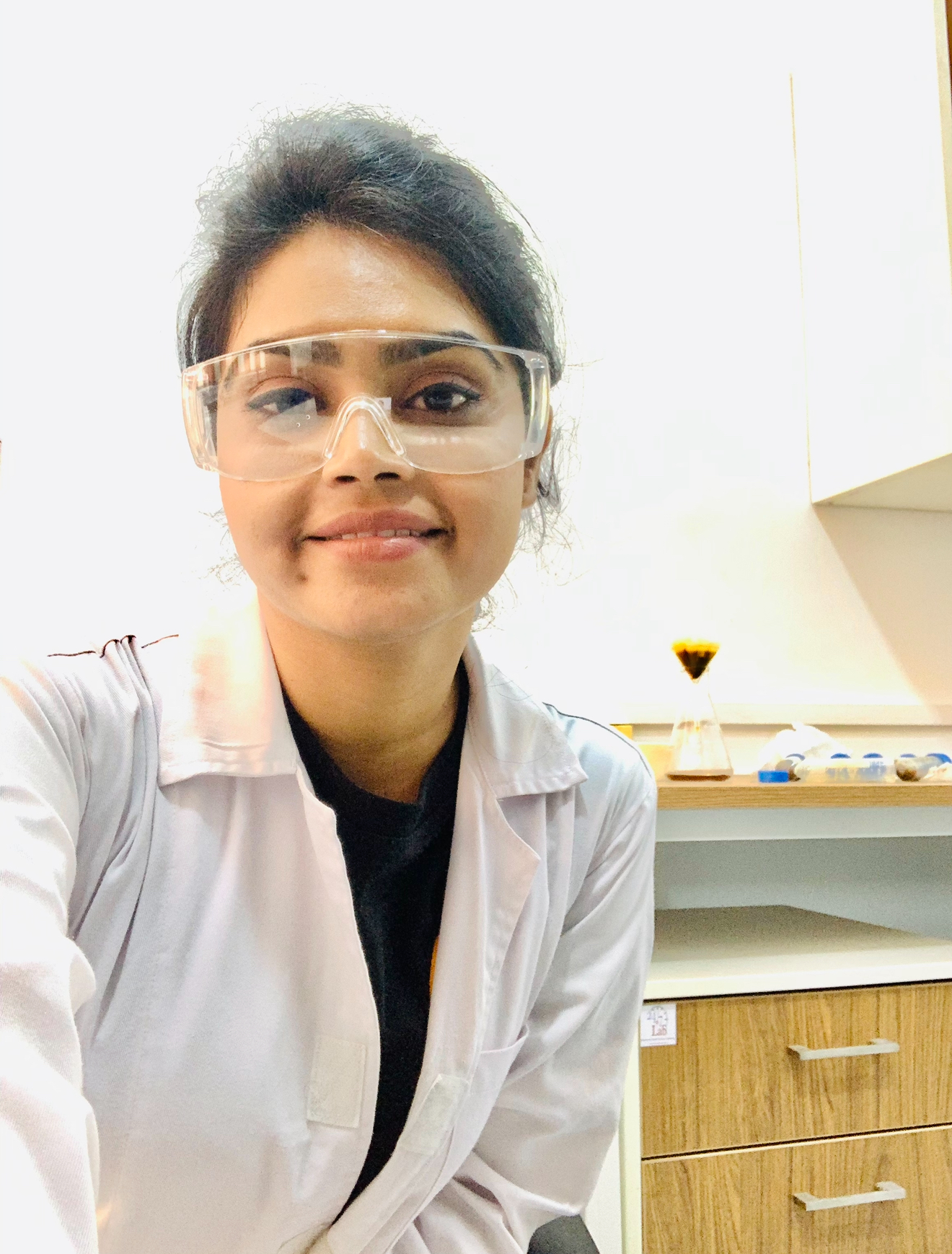 Sanali wearing laboratory safety goggles during PHA research