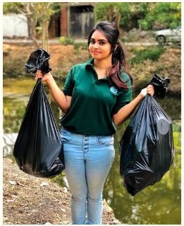 Sanali collecting waste during a community environmental cleanup